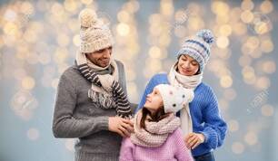 Family In Winter Clothes Over Christmas Lights Stock Photo, Picture and Royalty Free Image. Image 129631459.