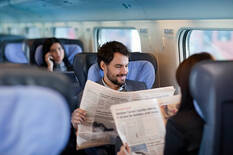 Businessman And Business Woman Reading Newspaper On A Train Stock Photo - Download Image Now - iStock
