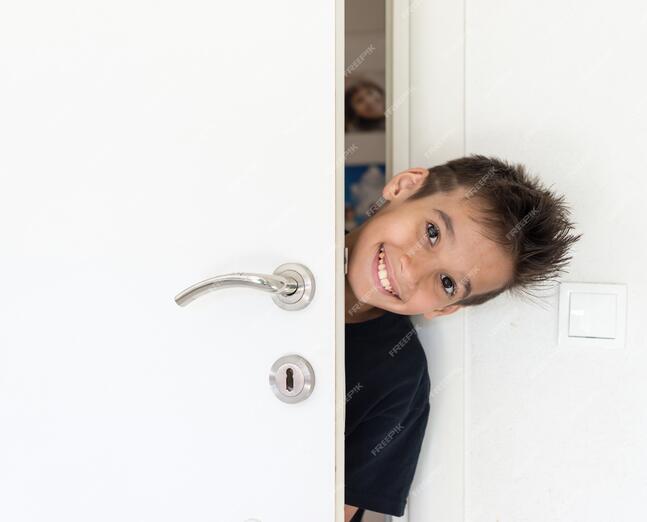 Premium Photo | Kid peeking out of the open room door